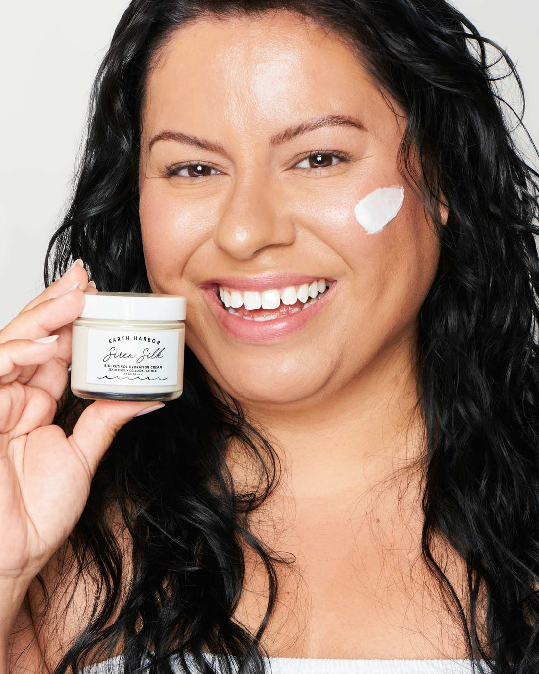 Earth Harbor Siren Silk - aplicacion facial modelo sosteniendo el envase