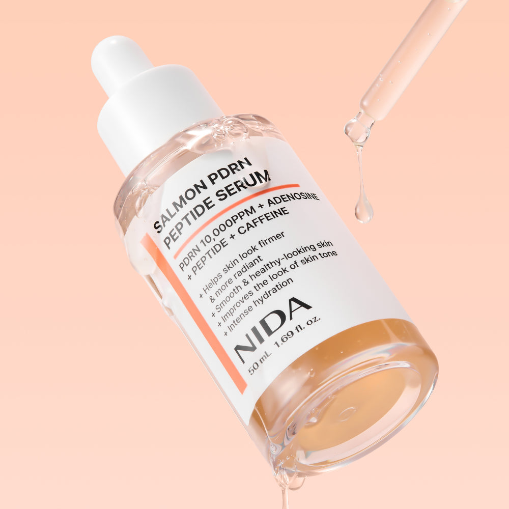 NIDA Salmon PDRN Peptide Serum frasco con gotero sobre fondo durazno — Glowup Makeup