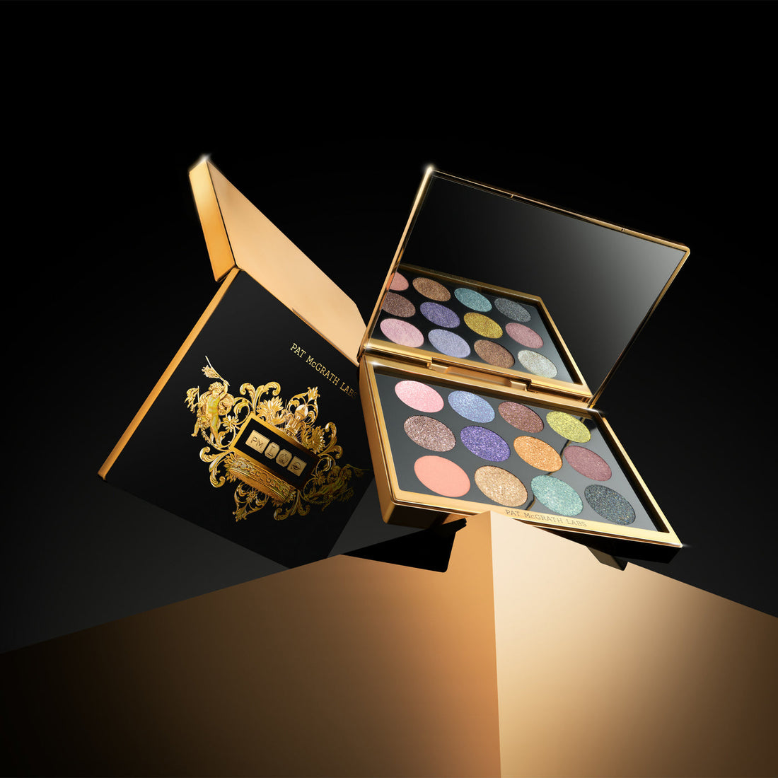Pat McGrath Labs Gilded Nirvana Mega Eye Shadow Palette, estuche de lujo abierto sobre fondo negro — Glowup Makeup
